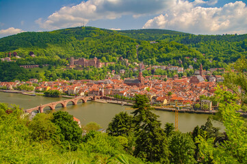 Fototapeta na wymiar Bird view over old historical downtown, Neckar river, city old bridge and forests at hills in Heidelberg at sunny summer day.