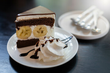 Chocolate Banana Cake in the Cafe On the wooden floor and whipped cream with sauce