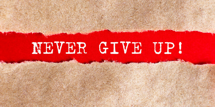 NEVER GIVE UP text on torn paper on red background