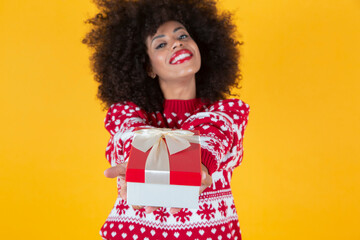 pretty woman with curly afro american hair, giving a christmas present, yellow background