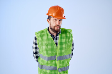 working man in orange hard hat construction professional blue background