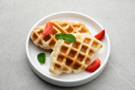 Croissant Waffle or Croffle with chocolate and strawberry topping on grey background. Selective focus image and close up.
