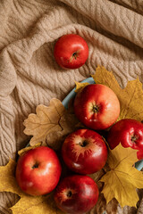 Naklejka na ściany i meble Red ripe apples scattered on beige textile surface