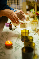 candle making process, small business concept at home, craftsman pours wax into a mold with a wick.