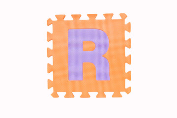 ''R" Jigsaw English orange purple foam alphabet puzzle pieces Isolated on white background. Jigsaw box with character English alphabet letter "R"  English It is universal language used all over world.