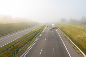 Cars on the highway on a foggy morning.