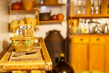 Wicker basket and very old utensils in wooden kitchen and vintage look.