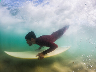 Obraz na płótnie Canvas Surfer duck diving a wave