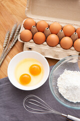 eggs in box and flour on the wooden table