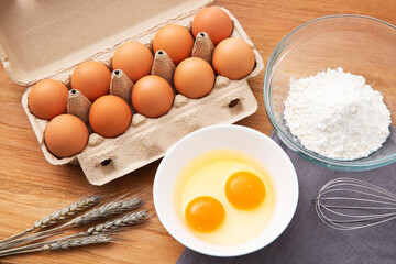 eggs in box and flour on the wooden table