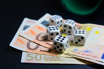 Some six-sided dice on some 50 euro bills with copy space