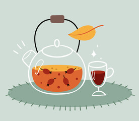 Rosehip tea in a transparent teapot. A glass of mulled wine. Warm autumn drink.