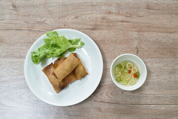 deep fried spring roll stuffed glass noodles with lettuce dipping sweet chili sauce on dish