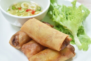 deep fried spring roll stuffed glass noodles with lettuce dipping sweet chili sauce on dish