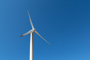 Renewable energy wind turbine placed on the high windward point of the mountain.