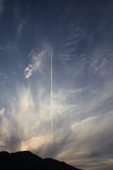 Naklejka na ściany i meble 夕焼け空に1本の飛行機雲 
