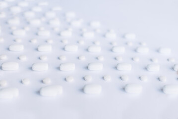 Many white pills on a white background. Health.