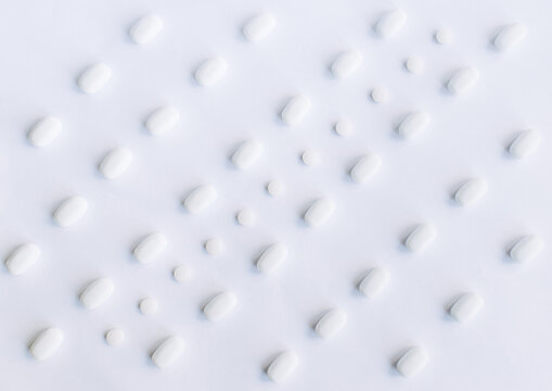Many white pills on a white background. Health. © Olena Svechkova