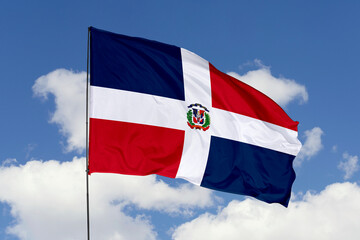 Dominican Republic flag isolated on the blue sky background. close up waving flag of Dominican Republic. flag symbols of Dominican Republic. Concept of Dominican Republic.