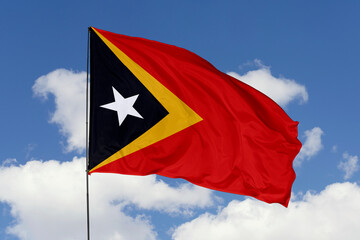 East Timor flag isolated on the blue sky background. close up waving flag of East Timor. flag symbols of East Timor. Concept of East Timor.