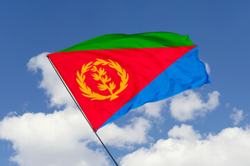 Eritrea flag isolated on the blue sky background. close up waving flag of Eritrea. flag symbols of Eritrea. Concept of Eritrea.