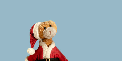 Vintage Santa Claus teddy bear isolated on light blue background. Christmas teddy bear. Empty space for text.