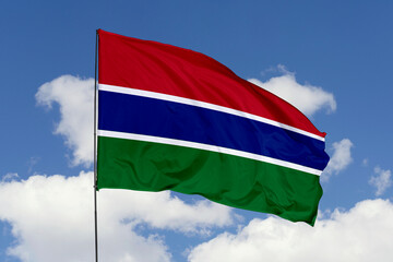 Gambia flag isolated on the blue sky background. close up waving flag of Gambia. flag symbols of Gambia. Concept of Gambia.