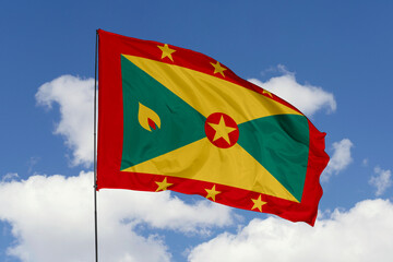 Grenada flag isolated on the blue sky background. close up waving flag of Grenada. flag symbols of Grenada. Concept of Grenada.