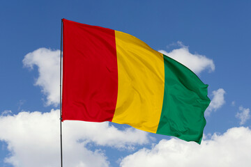Guinea flag isolated on the blue sky background. close up waving flag of Guinea. flag symbols of Guinea. Concept of Guinea.