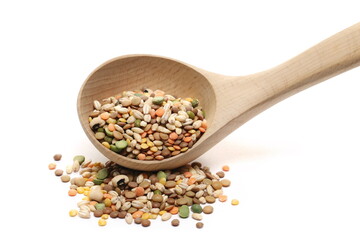 Mixed legumes and cereals, peeled barley, green, yellow and dark red lentils, half green peas, black white beans, green beans with wooden spoon isolated on white background