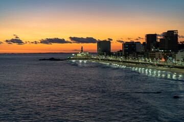 Fototapeta premium Sunset over Barra beach and Barra lighthouse (Portuguese: Farol da Barra), the oldest lighthouse in South America, in Salvador, Bahia, Brazil.