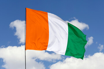 Ivory Coast flag isolated on the blue sky background. close up waving flag of Ivory Coast. flag symbols of Ivory Coast. Concept of Ivory Coast.