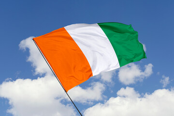 Ivory Coast flag isolated on the blue sky background. close up waving flag of Ivory Coast. flag symbols of Ivory Coast. Concept of Ivory Coast.