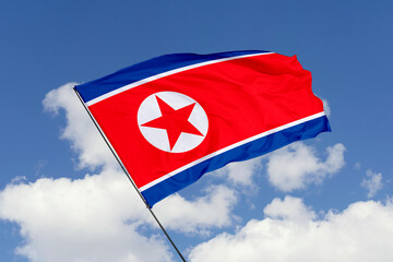 North Korea flag isolated on the blue sky background. close up waving flag of North Korea. flag symbols of North Korea. Concept of North Korea.