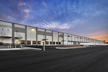 Fotobehang Modern warehouse distribution center at sunset © Brian