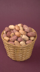 Fototapeta na wymiar Groundnuts in wooden bowl isolated on plane background, salted roasted peeled nuts, top view