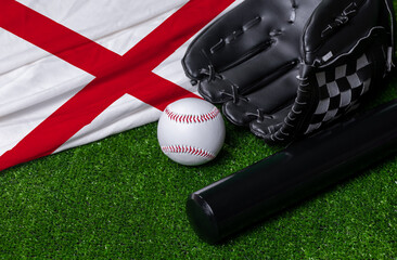 Baseball bat, glove and ball near Alabama flag on green grass background