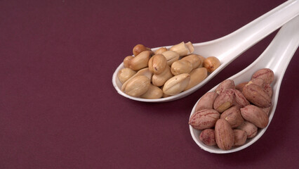 Groundnuts in wooden bowl isolated on plane background, salted roasted peeled nuts, top view