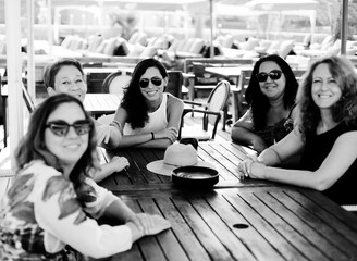 Women best friends sitting in summer cafe on the beach