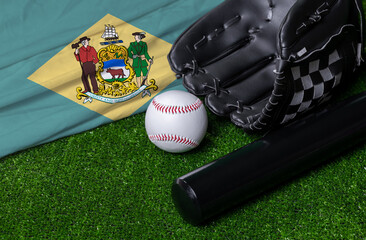 Baseball bat, glove and ball near Delaware flag on green grass background
