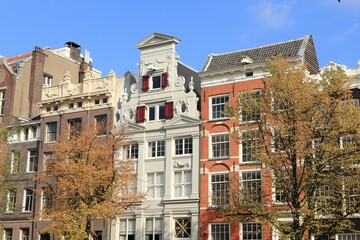 Fototapeta na wymiar Amsterdam Keizersgracht Historic House Facades with Autumn Trees and Blue Sky, Netherlands