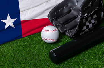 Baseball bat, glove and ball near Texas flag on green grass background