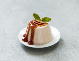 Vegan pudding, Plum Panna Cotta with topping on a plate on a light gray background