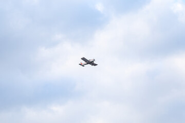 Small private flying airplane yet flying in the sky with cloudy weather.