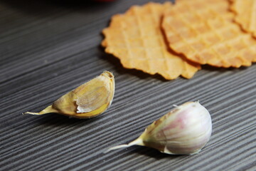 cloves of garlic and diet waffles on dark wooden background