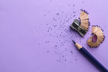 Blue pencil, shavings, crumbs and sharpener on violet background, flat lay. Space for text