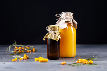 sea buckthorn berry products - oil, juice, rectal candles on a wooden background