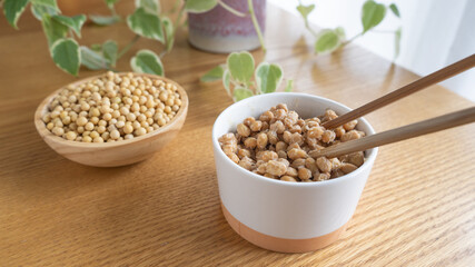 日本の納豆と生大豆。納豆を箸で混ぜる。	