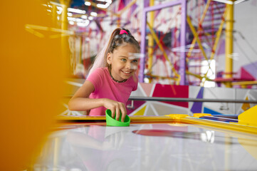 Little girl play air hockey, entertainment center