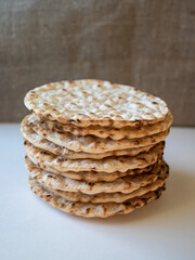 Stack of round crispbreads on white/textile background